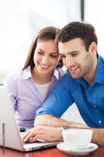 Photo: Young couple using laptop Young couple using laptop