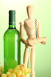 Mannequin with corkscrew and wine bottle, on green background