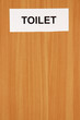 Toilet sign on wooden background