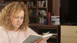 Pretty girl reading book in home - tracking shot