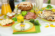 Serving Easter table with tasty dishes on room background