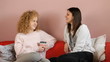 Two teen friends talking in sitting-room