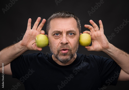 Photo: middle-aged man with a green apples middle-aged man with a green apples
