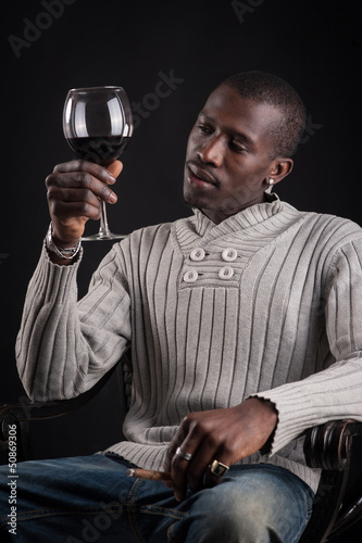 Photo: Confident portrait of african man tasting glass of red wine. Confident portrait of african man tasting glass of red wine.