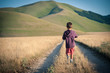 Kid walking alone outdoors. Castelluccio di Norcia, Italy.
