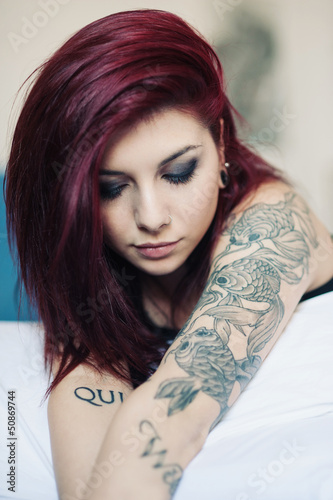 Photo: Sensual portrait of beautiful girl with tattoo lying on bed. Sensual portrait of beautiful girl with tattoo lying on bed.