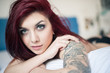 Photo: Sensual portrait of beautiful girl with tattoo lying on bed. Sensual portrait of beautiful girl with tattoo lying on bed.