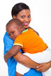 portrait of young african nurse carrying sleeping baby boy