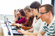 College students sitting in a classroom, using laptop computers
