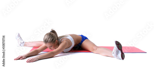 Photo: Athletic girl doing stretching exercises on mat Athletic girl doing stretching exercises on mat