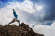 Photo: Woman doing yoga warrior pose on mountain Woman doing yoga warrior pose on mountain