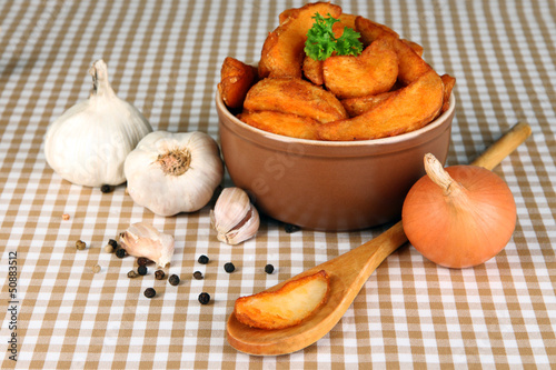 Photo: Appetizing village potatoes in bowl on beige tablecloth Appetizing village potatoes in bowl on beige tablecloth