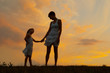 Mother and daughter holding hands in the nature