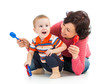 Mother and baby boy having fun with musical toys. Isolated on wh