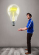 Attractive man holding realistic 3d light bulb