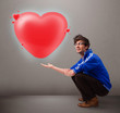 Young man holding lovely 3d red heart
