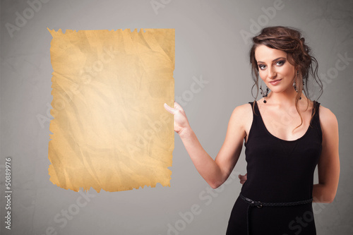 Photo: Young girl presenting old paper copy space Young girl presenting old paper copy space