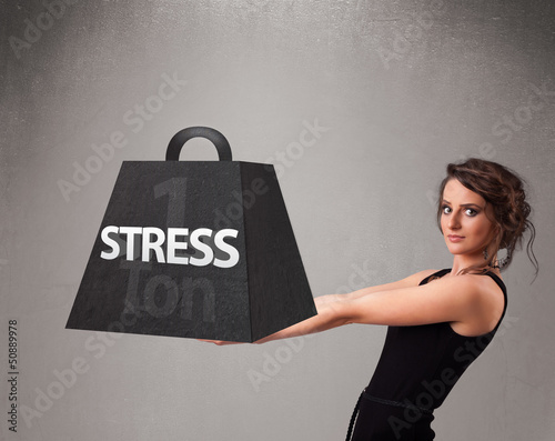 Photo: Young woman holding one ton of stress weight Young woman holding one ton of stress weight