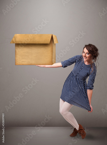 Photo: Young woman holding an empty cardboard box Young woman holding an empty cardboard box