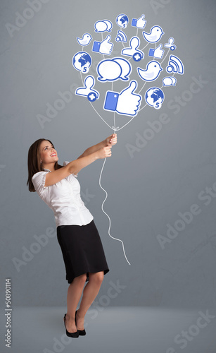 Photo: Pretty woman holding social icon balloon Pretty woman holding social icon balloon