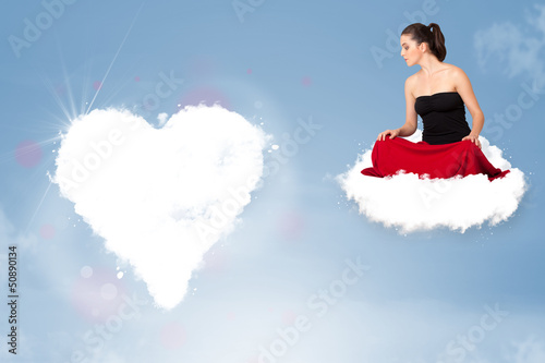 Photo: Beautiful lovely woman sitting on cloud with heart Beautiful lovely woman sitting on cloud with heart