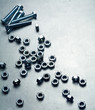 Foto: Nuts and screws on a metal plate Nuts and screws on a metal plate