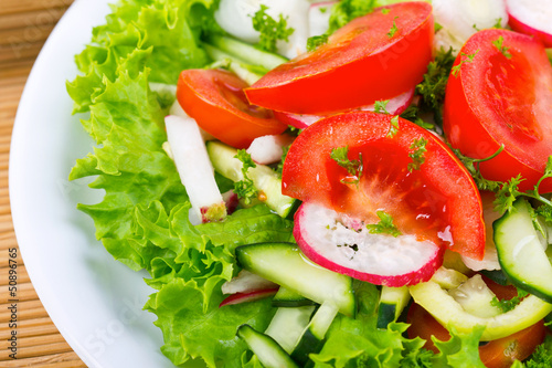 Photo: Plate with fresh salad close - up Plate with fresh salad close - up