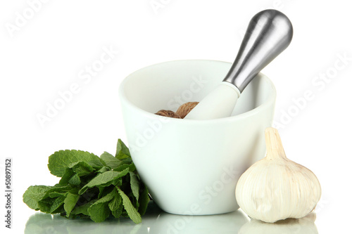 Photo: Mortar, herbs and garlic, isolated on white Mortar, herbs and garlic, isolated on white