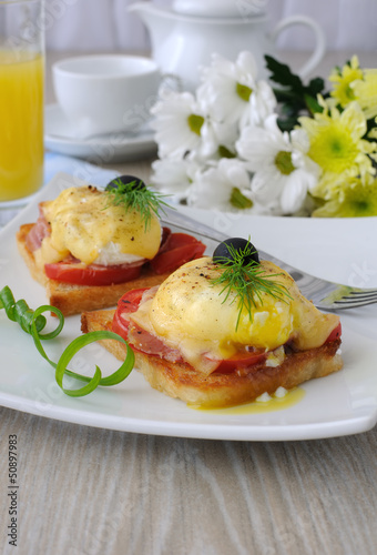 Photo: Eggs Benedict with ham and tomato on toast with cheese Eggs Benedict with ham and tomato on toast with cheese