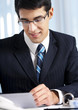 Successful businessman with documents at office