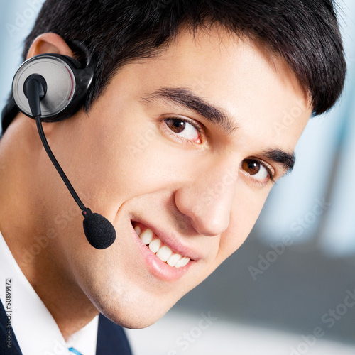Photo: Support phone operator in headset at workplace Support phone operator in headset at workplace