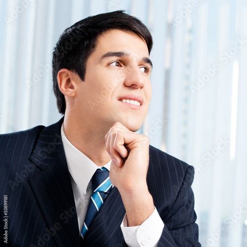 Photo: Portrait of thinkihg businessman at office Portrait of thinkihg businessman at office