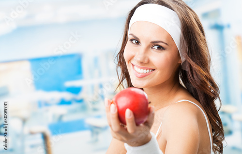 Photo: Woman with apple, at fitness center Woman with apple, at fitness center