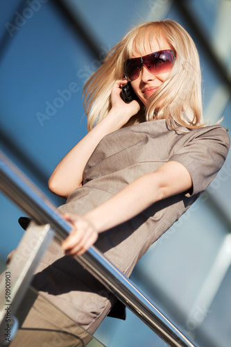 Photo: Blond woman calling on the phone Blond woman calling on the phone