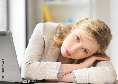 Photo: bored and tired woman behind the table bored and tired woman behind the table