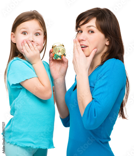 Photo: Little girl and her mother are anxious about time Little girl and her mother are anxious about time