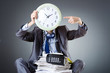 Man with clock and pile of papers