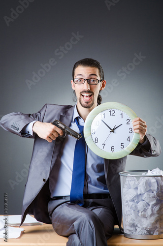 Photo: Man with clock and pile of papers Man with clock and pile of papers