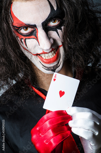 Photo: Evil clown with cards in dark room Evil clown with cards in dark room