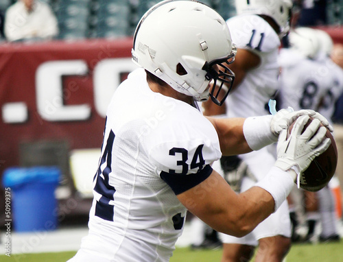 Photo: Football player catching the football Football player catching the football