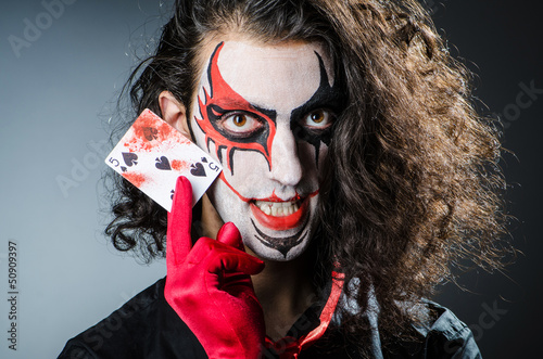 Photo: Evil clown with cards in dark room Evil clown with cards in dark room