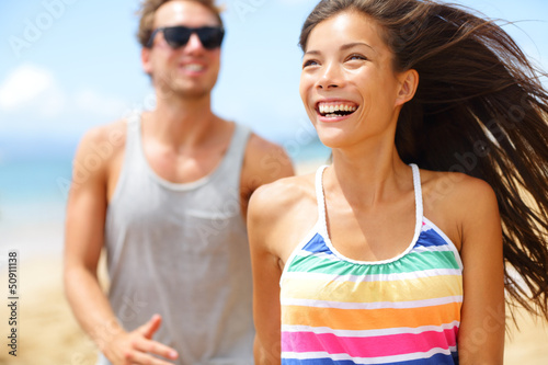 Photo: Young happy couple laughing having fun on beach Young happy couple laughing having fun on beach