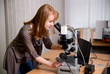 beauty researcher looking through microscope in laboratory