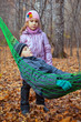 A boy with his sister relaxing in hammock in autumn forest