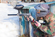 player in paintball aims for shelter in game on sunny day