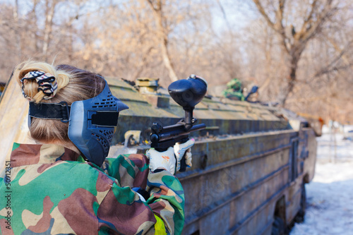 Photo: player in paintball aims for shelter in game on sunny day player in paintball aims for shelter in game on sunny day