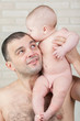 Foto: Naked baby boy kissing a happy father. Naked baby boy kissing a happy father.