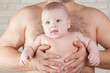 Baby boy on the strong hands of his father