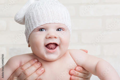 Photo: Portrait of a smiling baby in a white hat in my mother's arms Portrait of a smiling baby in a white hat in my mother's arms