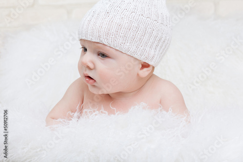 Photo: Side portrait of a concentrated baby in a white hat Side portrait of a concentrated baby in a white hat